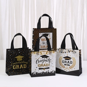 Set of four non-woven graduation gift bags with gold letters and black handles