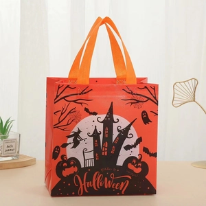 Detail of Halloween non-woven gift bag with witch, castle and pumpkin prints in orange