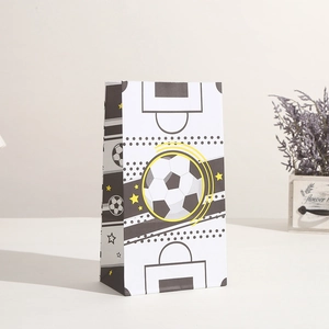 Detail einer Geschenktüte mit Fußballmotiven, gelben Kurven und sportlichem Design