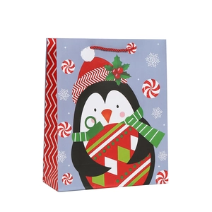 Christmas gift bag with cute penguin print and red handle for festive party packaging