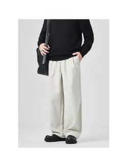 Detail shot of beige wide-leg trousers showing drape texture and premium fabric quality