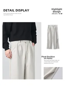 Detail view of light grey wide-leg trousers showing pleated hem and premium wool texture