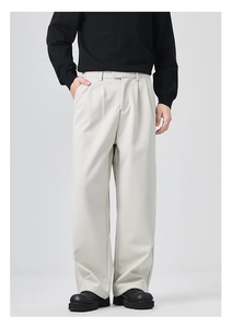 Close-up of beige wide-leg men's trousers featuring front pleats and draped fabric texture
