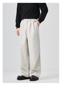 Detail of light gray wide-leg men's trousers with soft draped texture and waist pleats
