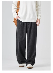 Detail of dark grey wide-leg men's casual trousers with premium drape and textured fabric