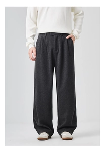 Detail of dark grey pleated straight-leg trousers with premium heavy fabric texture