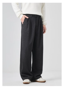 Detail of dark grey wool wide leg trousers showing thick fabric texture and elegant drape
