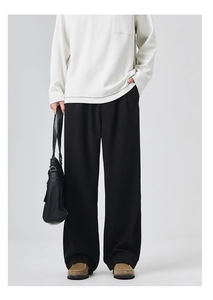 Close-up of black wide-leg trousers for men featuring smooth drape fabric and stylish fit