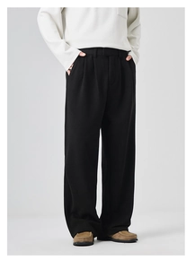 Detail view of men's loose wide-leg casual trousers in black with high-quality drape fabric