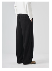 Men's relaxed black wide-leg trousers featuring elastic drawstring waist and side-back view