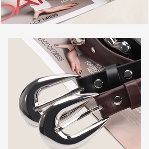 Détail de la boucle en métal argenté en forme de cœur et rivets sur ceinture en cuir