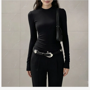 Détail d'une ceinture en cuir PU noir avec boucle à rivets en forme de cœur sur un t-shirt