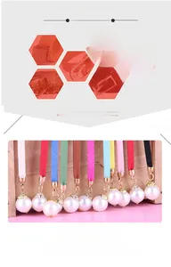Detail view of colorful velvet rope necklaces with large imitation pearl pendants