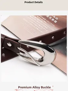 Détail d'une ceinture en cuir PU marron avec rivets en forme de cœur et boucle argentée