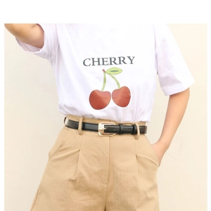 Close-up of a slim black PU leather belt with a gold alloy buckle on khaki shorts