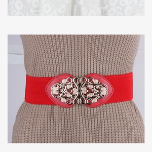 Détail de la ceinture élastique rouge avec boucle métallique dorée évidée vintage sur robe
