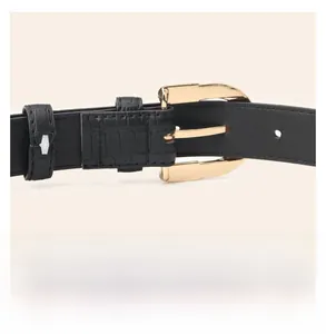 Detail view showing smooth gold alloy buckle back and crocodile pattern leather belt texture