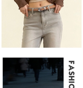 Detailed view of women's brown belt with crocodile texture and silver oval buckle on jeans