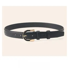 Detail shot of black faux leather belt with crocodile texture and gold D-ring buckle