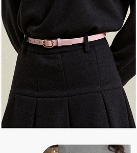 Detail shot of a slim light pink leather belt featuring an elegant oval golden buckle