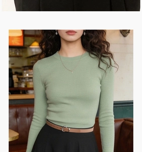 Detail shot of light green ribbed knit top styled with a chic brown leather belt