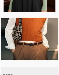 Women's dark brown leather belt styled with high-waisted pants and a knit vest outfit