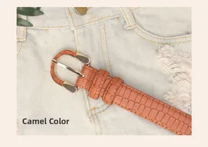 Detail of camel stone pattern leather belt with golden D-shaped buckle on denim jeans