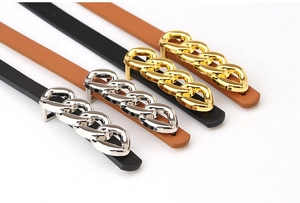 Close-up of elegant leather waist belts with gold and silver chain buckles in black and brown