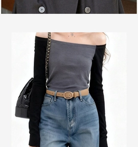 Detail of light brown belt with square metal buckle paired with blue denim jeans