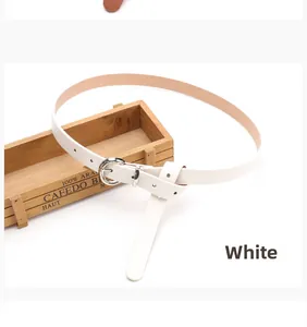 Slim white leather belt with silver round buckle displayed on vintage wooden box