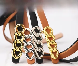 Detail of elegant waist belts with gold and silver metal interlocking chain buckles