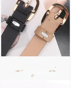 Detail view of thin PU leather belts in black and beige with elegant gold oval buckles