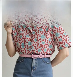 Detail of pink floral leather belt styled with floral blouse and high-waisted denim jeans