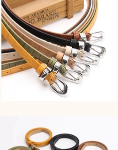 Detailed close-up of slim crocodile texture leather belts with polished silver buckles