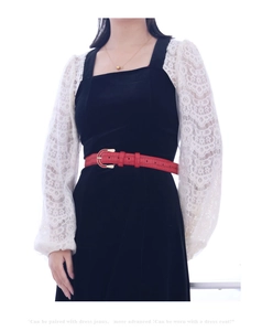 Close-up of red crocodile pattern leather belt with golden horseshoe buckle
