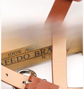 Close-up of brown leather belt with polished silver alloy buckle and fine stitching