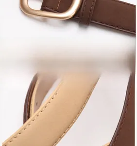 Detail of coffee brown nubuck leather belt with matte alloy buckle and fine stitching
