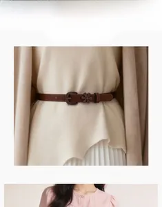 Detail of dark coffee leather belt featuring an intricate floral buckle for dresses