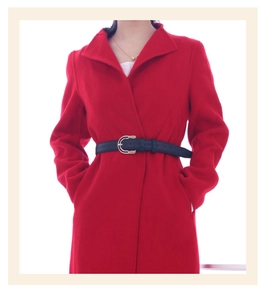 Close-up of red wool coat with a slim black leather belt and golden C-shaped buckle