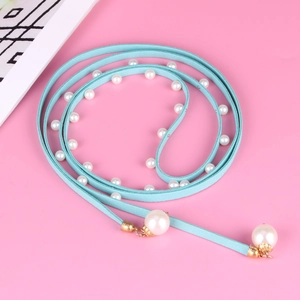 Blue velvet choker necklace with white pearls and gold accents on pink background