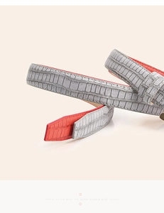 Detailed close-up of grey crocodile embossed leather belt with vibrant red inner lining