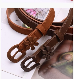 Detail of slim waist belts with floral buckle in caramel and dark brown for dresses