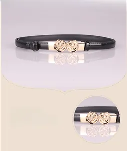 Detail der goldene Rosen-Schnalle und das schwarze Lackleder am Damengürtel im Zoom