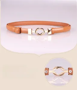 Detail view of caramel brown skinny belt featuring a golden interlocking alloy buckle