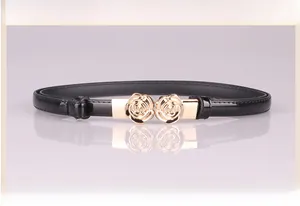 Detailansicht der goldenen Rosenschnalle auf glänzendem schwarzem Lackleder-Gürtel