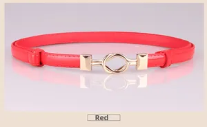 Close-up of a red glossy skinny belt featuring a stylish double interlocking gold ring buckle