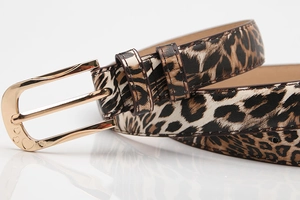 Close-up of leopard print belt with gold needle buckle and hollow heart-shaped relief details