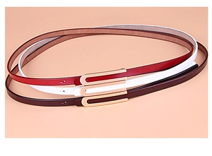 Détail de ceintures fines en cuir bordeaux, blanc et marron avec boucles dorées