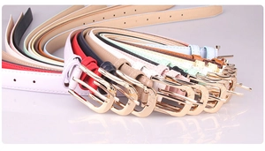 Detail of colorful PU leather thin belts with polished gold alloy buckle and neat stitching