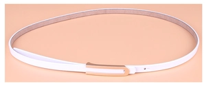 Détail d'une ceinture fine en cuir blanc avec une boucle en métal doré en forme de U